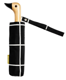 A black and white umbrella with a duck head on top of the pole with a black beak.