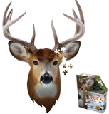 A puzzle that is shaped like a buck. There are puzzle pieces missing from it and some next to its ear. Next to it is a puzzle box with text that says, "I Am Buck. Head-shaped jigsaw puzzle. 17" x 24". 300 pieces. For ages 10+." There is a picture of a buck on the side of the box with puzzle pieces coming out of it.