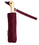 A red umbrella with a duck head at the top of the pole with a red beak.