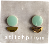 Circular aqua-colored earring studs with a golden half-moon shape on the bottom of them.