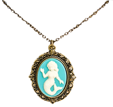 A blue pendant on a necklace chain with a white mermaid in the center. The outside is gold with an ornate design.
