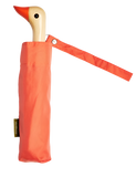 A peach-colored umbrella with a duck head at the top of the pole with a peach-colored beak.