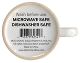 The bottom of the signal flags mug. It is white and has text that says, "Wash before use. Microwave safe. Dishwasher safe."