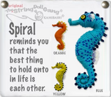 String dolls of seahorses. They are blue, orange, and yellow. There is text on the side that says, "Spiral reminds you that the best thing to hold onto in life is each other."