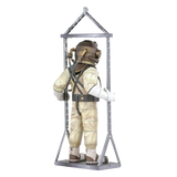 Back of assembled metal model of a vintage diving suit with a metal stand on a white background