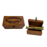 A brass telescope displayed inside an open wooden presentation box, with the matching wooden box shown closed beside it. The closed box has an engraved whale design and the words 'Whale Watch'.