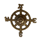 A vintage-style brass compass wheel paperweight with ornate directional figures at the ends of each arm