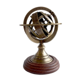 A brass armillary sphere model with engraved rings and a wooden base