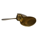 A modern sculptural spoon-shaped wall decor piece made of brushed brass, shown from the side
