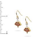 Gold earrings with red accents and pearls on a white background with a ruler for scale.