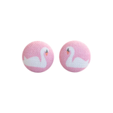 A pair of round pink fabric-covered buttons with a white swan design