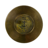 Back of bronze compass with a central engraved anchor emblem and nautical script