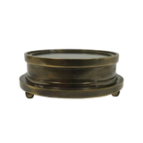 An antique-style round brass pedestal base with a circular top and three small feet