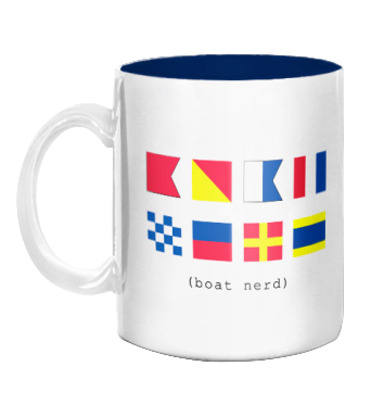 White mug with colorful signal flags and text 'boat nerd' on a white background
