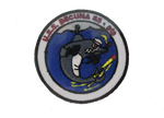 An embroidered patch of a cartoon of the Becuna. The Becuna is characterized as a strong, almost shark-looking cartoon character who is withstanding torpedoes. There is text at the top of the patch that reads, "U.S.S. Becuna SS - 319."