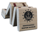 A wooden Jacob's ladder toy that has the text "Independence Seaport Museum" on it, along with the logo of an anchor on a wave encased in a circle and surrounded by stars.