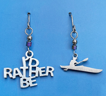 Stainless steel earrings, one that states "I'd rather be" and another shaped like a a person in a kayak, made with stainless steel ear wires, and accented with a hematite bead.