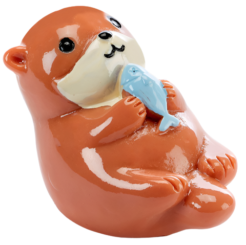 A tub of lip balm shaped like an otter. The otter has a brown body and a white snout and face. It is holding a blue fish up to its chin. 