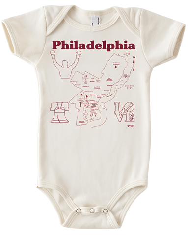 A white onesie that has illustrations of a map of Philadelphia and some Philadelphia-specific iconography, like the Liberty Bell, Rocky, and the Love sign. There is text on the top of the onesie that says, "Philadelphia." 