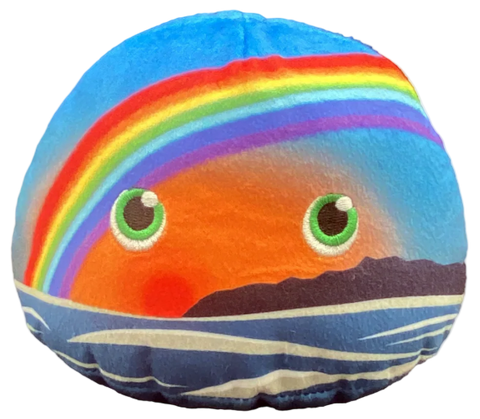 Plush depicting rainbow over a sunset on the oceanside with green eyes