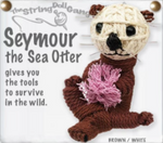 A string doll of a sea otter. It has a tan face with black eyes, nose, and mouth, and brown ears and body. It is holding some coral. Text on the side states, "Seymour the Sea Otter gives you the tools to survive in the wild." 