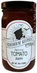 A jar of tomato jam. There is a white label on it with an illustration of the silhouette of a sailor's face, who is smoking a pipe. There are two birds flying above him. There is a banner underneath him that says, "Lighthouse Keeper's." Underneath that, it says, "Spicy tomato jam."