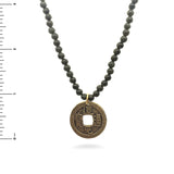Necklace with jade beads and a gold coin pendant with Chinese characters with  a ruler for scale
